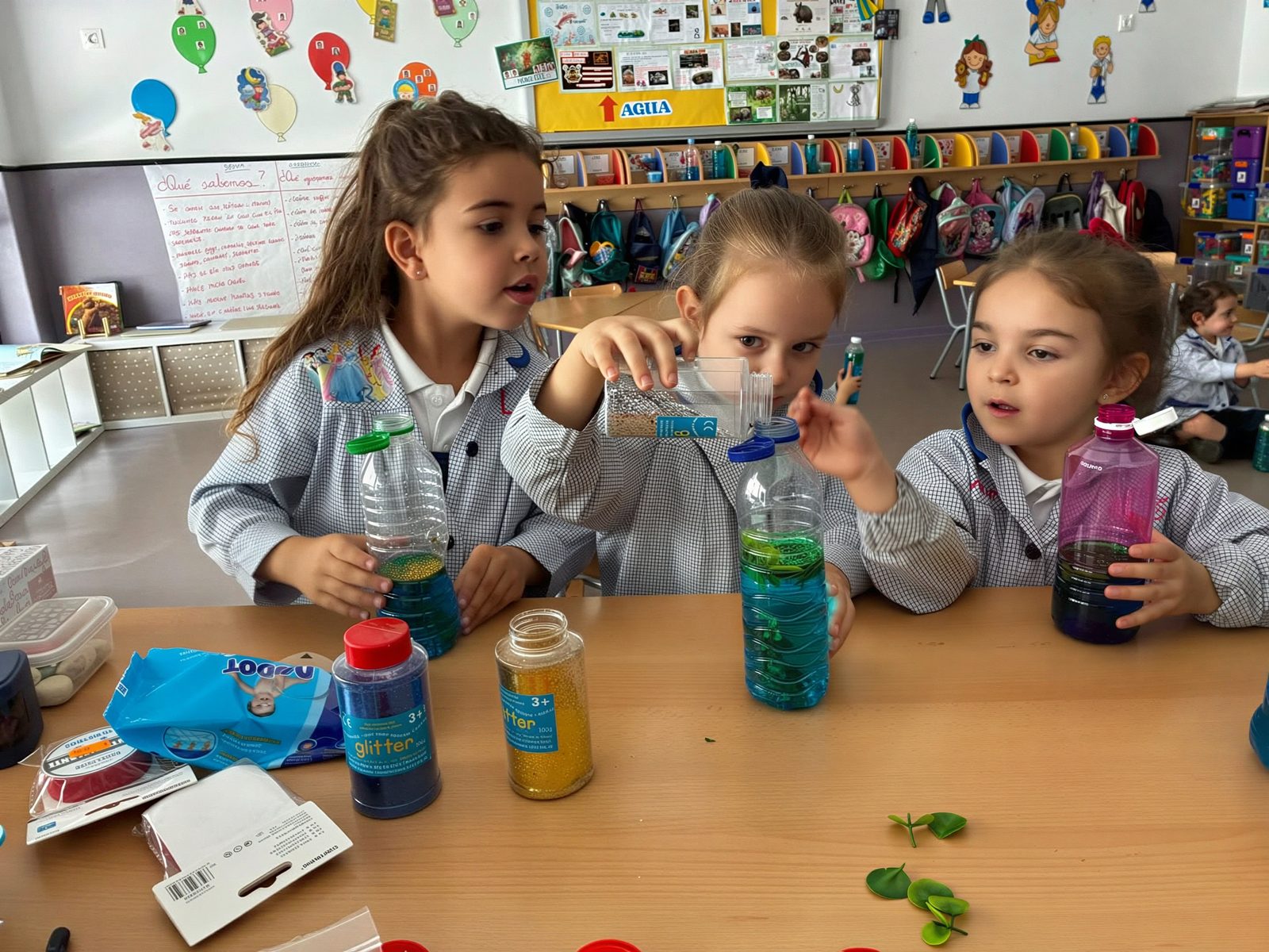 Alumnas de Infantil realizando un experimento con líquidos de colores