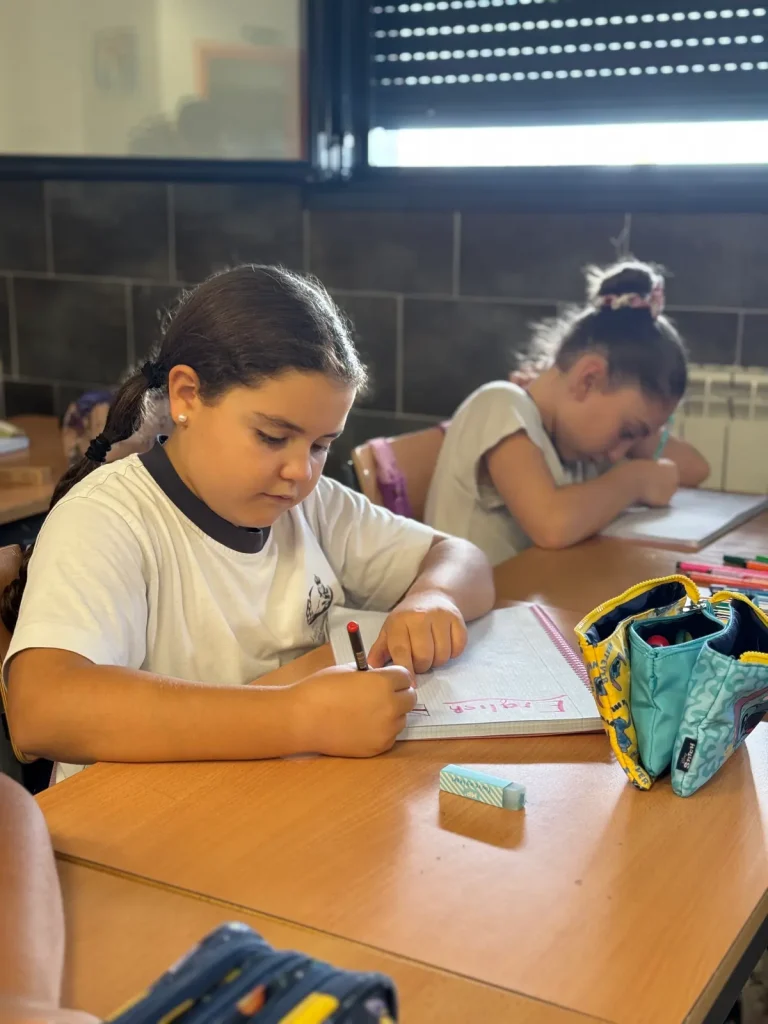 Alumna de Primaria escribiendo con rotulador en su cuaderno