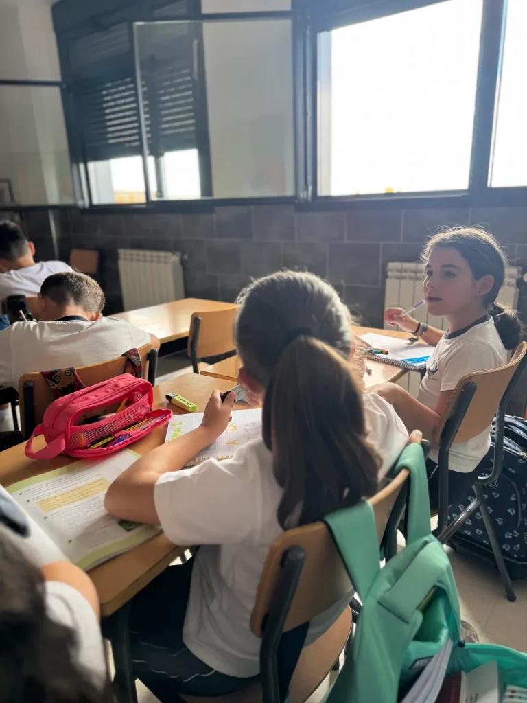 Alumnas trabajando en sus mesas en un aula luminosa del Colegio Virgen de la Caridad