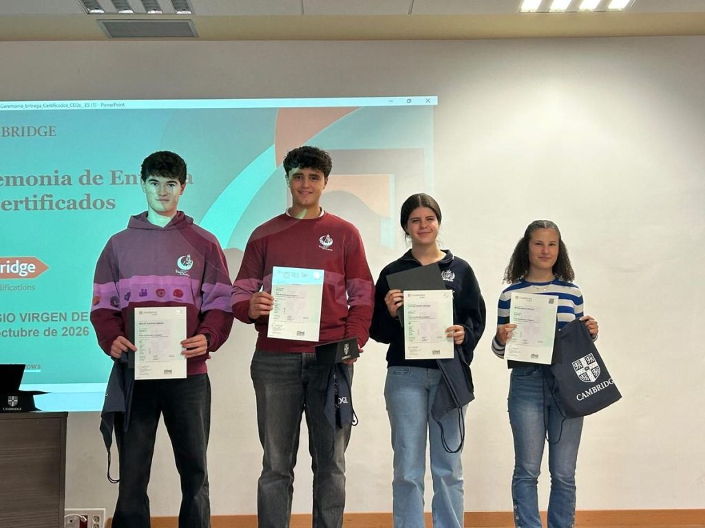 Alumnos de secundaria mostrando sus certificados de Cambridge en el escenario