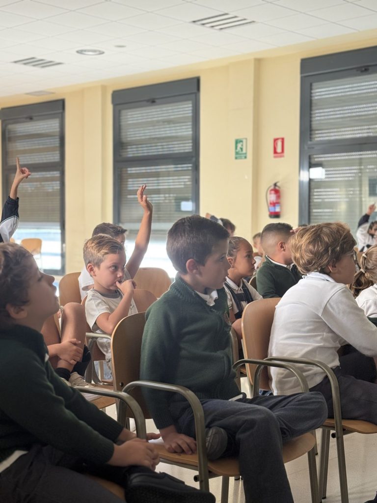 Alumnos de 2.º de Primaria levantan la mano para preguntar
